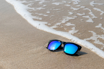 Fototapeta na wymiar Sun glasses on the sand beach