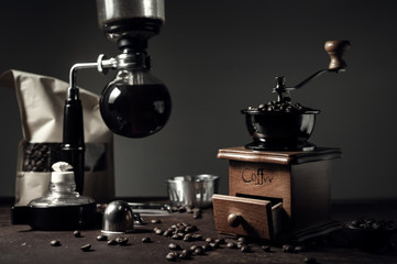 Japanese siphon coffee maker and coffee grinder on old kitchen table background, It is very fragrant and aroma because filled with fresh coffee beans.