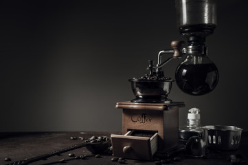 Japanese siphon coffee maker and coffee grinder on old kitchen table background, It is very fragrant and aroma because filled with fresh coffee beans.