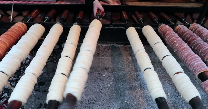 Hungarian cinnamon chimney cake sweet dessert being cooked grilled prepared on the street4
