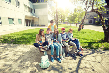 Fototapeta premium education, high school and people concept - group of happy teenage students with notebooks learning at campus yard