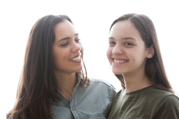 Portrait of wwo girlfriends who are laughing are having fun over white background