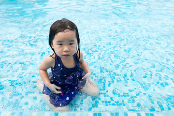 Fototapeta na wymiar Portrait of Asian little baby girl playing in swimming pool