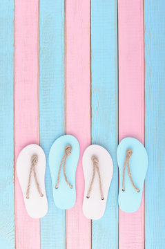 Colored flip flops on Soft pink and light blue wooden planks background Trendy vanilla pastel colors Top view and copy space Flat lay Minimal Summer design Vertical