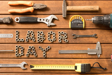 Labor day. Different tools on wooden background .