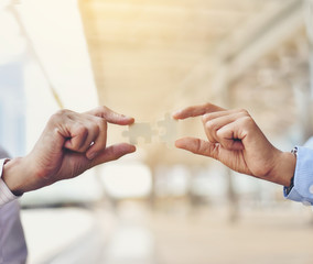 Businessmen hold jigsaw puzzles for each other. Business teamwork concept