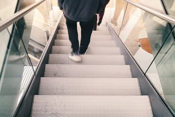 blurred legs of a person go down a staircase