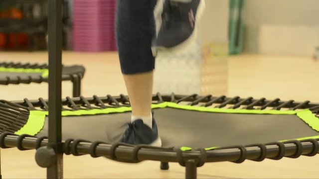 Closeup woman feet legs in sneakers on a trampoline jumping  in the gym healthy strong sport , happiness fitness fit activity 