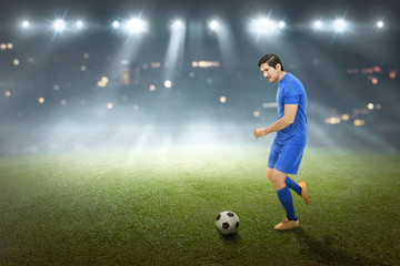 Obraz na płótnie Canvas Spiritful asian male footballer kick the ball