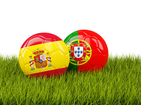 Spain vs Portugal. Soccer concept. Footballs with flags on green grass