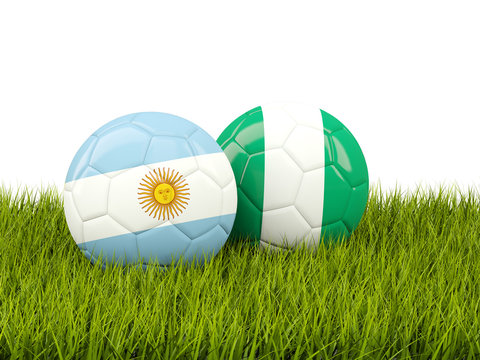 Argentina vs Nigeria. Soccer concept. Footballs with flags on green grass