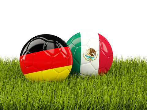 Germany vs Mexico. Soccer concept. Footballs with flags on green grass