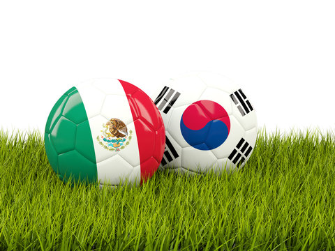 Mexico vs South Korea. Soccer concept. Footballs with flags on green grass