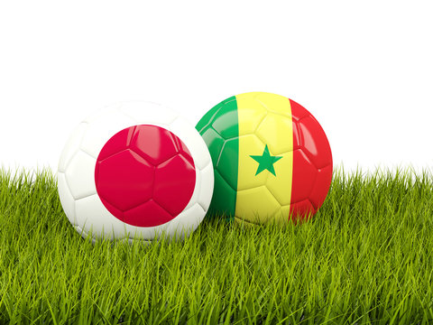 Japan vs Senegal. Soccer concept. Footballs with flags on green grass
