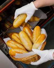 baking croissant bun baker pull fresh oven hand basket female yellow orange hot crisp sweet pastry bakery bake cooking