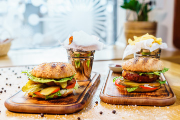 Burger with lard, veal cheese and lettuce. American Traditional Food. On a wooden background.