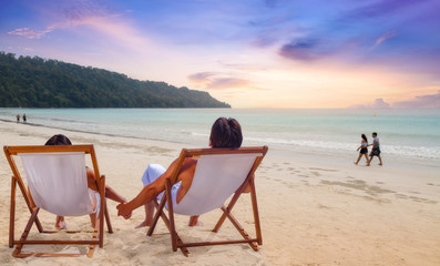 Couple enjoy beach sunset at the Havelock islands Andaman India. Photograph shot with selective focus.