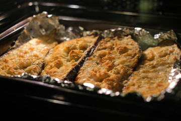 Eggplant / Aubergine with cheese topping beeing baked in oven