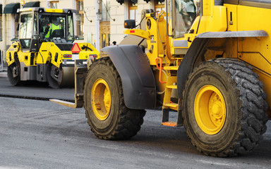 Road re-construction. Road roller stacking hot asphalt.