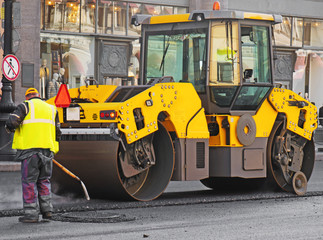 Road re-construction. Road roller stacking hot asphalt.