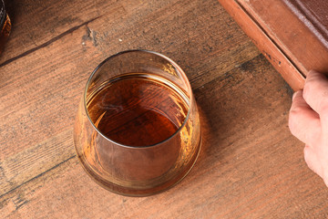 whiskey on wooden table with hand model