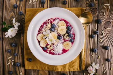 Smoothie bowl on white plate on wooden table