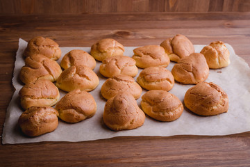 fresh eclairs on parchment wooden table