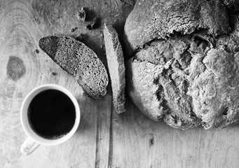Loaf of homemade freshly baked bread and cup of coffee on the table