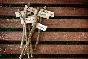creative plant markers on a wooden table labeled with herb names for the rural garden, do it...