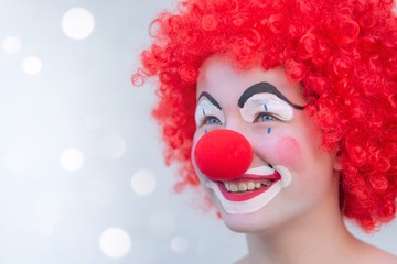 Funny kid clown with red nose playing