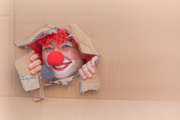 Funny kid clown with red nose playing