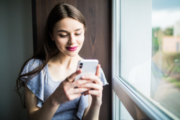 Fototapeta premium Gorgeous young woman r checking email and sending sms message on mobile phone