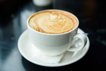 Cappuccino in a white cup on restaurant table