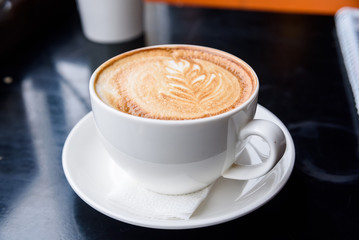 Cappuccino in a white cup on restaurant table