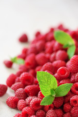 Fresh organic raspberries with mint leaves. Fruit background with copy space. Summer and berries harvest concept. Vegan, vegetarian, raw food.