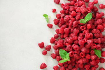 Fresh organic raspberries with mint leaves. Fruit background with copy space. Summer and berries harvest concept. Vegan, vegetarian, raw food.