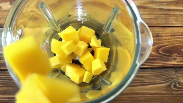 Prepare to cooking mango smoothie, puts mango in blender