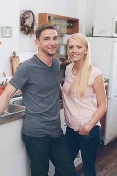 Portrait of smiling couple standing in kitchen