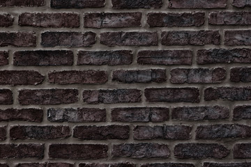 Dark brown rough brick wall close-up texture for background