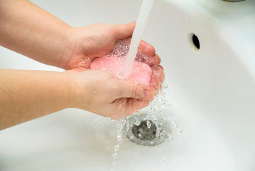 Woman washing hands with soap in sink