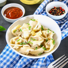Homemade ready dumplings on a gray concrete table.