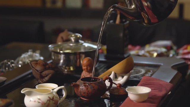 Tea ceremony. Tea maker pours boiling water into the teapot.