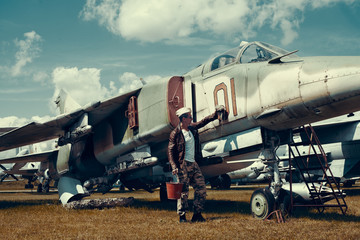 Fighter Pilot with sunglasses in full flight gear standing at the front of his jet