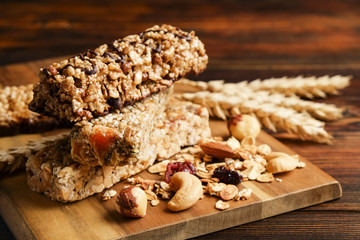 Bunch of mixed gluten free granola energy bars with dried fruit & various nuts, wooden background. Healthy vegan super food, different fitness diet snacks for sporty lifestyle. Top view, copy space.