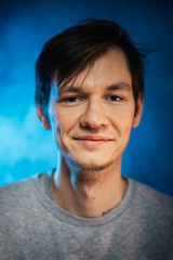 portrait emotional young man on blue background