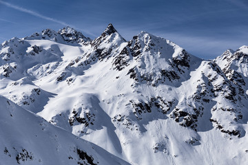 Ausblick ein Gebirge in den Alpen im Winter unter blauem Himmel