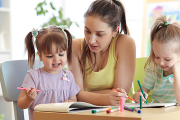 children and teacher drawing pencils in artschool