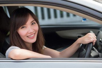 happy woman driving personal car; portrait of happy, smiling, joyful asian woman driving her car, left hand driving or left hand traffic style; 30s adult asian Chinese woman model