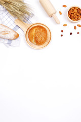 Homemade breads or bun, croissant and bakery ingredients, flour, almond nuts, hazelnuts, eggs on white background, Bakery background frame, Cooking breakfast concept. Flat lay, Top view and copy space