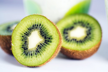 Fototapeta na wymiar Ripe whole kiwi fruit and half kiwi fruit on white background